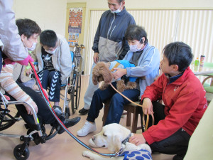 犬を囲んで笑顔の利用者さんたち